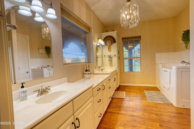 7444 Caldwell Canyon Rd, Snowflake, AZ 85937 - full bath with a chandelier, double vanity, a garden tub, independent washer and dryer, and wood finished floors