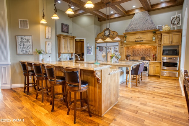 7444 Caldwell Canyon Rd, Snowflake, AZ 85937 - kitchen with appliances with stainless steel finishes, a warming drawer, a towering ceiling, coffered ceiling, and a breakfast bar