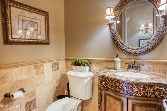 7444 Caldwell Canyon Rd, Snowflake, AZ 85937 - bathroom with toilet, vanity, a wainscoted wall, and tile walls