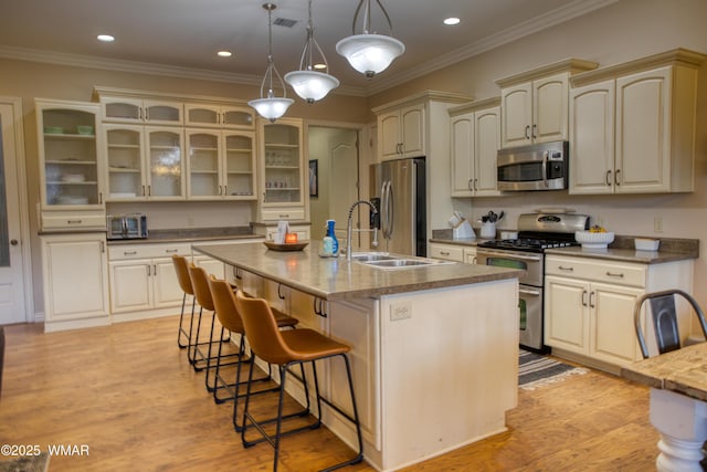 7444 Caldwell Canyon Rd, Snowflake, AZ 85937 - kitchen featuring appliances with stainless steel finishes, a sink, a breakfast bar, cream cabinets, and an island with sink