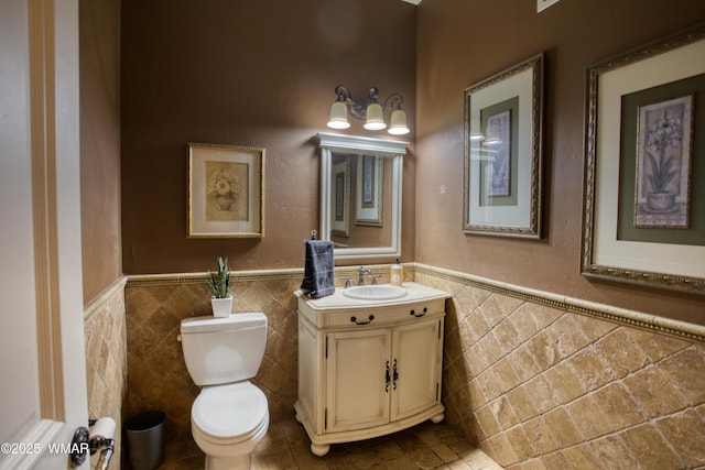 7444 Caldwell Canyon Rd, Snowflake, AZ 85937 - half bathroom with tile walls, vanity, a wainscoted wall, and toilet