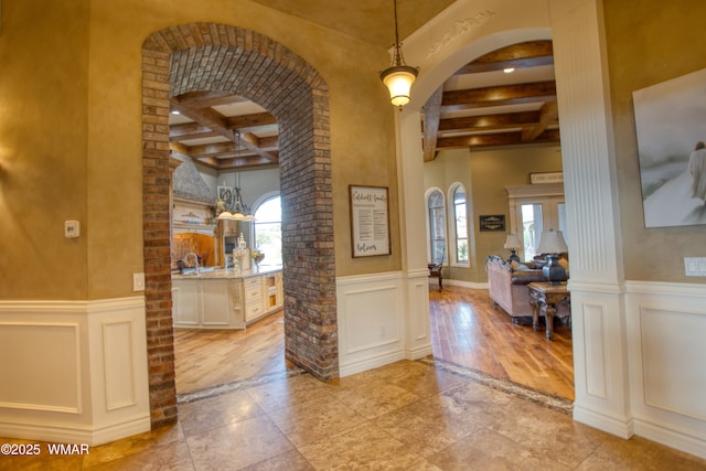 7444 Caldwell Canyon Rd, Snowflake, AZ 85937 - foyer featuring beamed ceiling, arched walkways, coffered ceiling, wainscoting, and a decorative wall