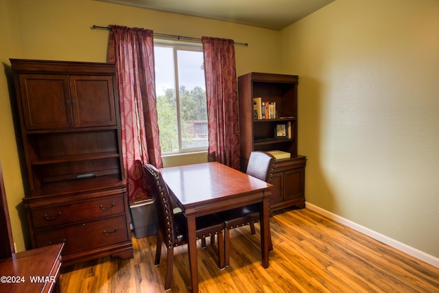 dining room with baseboards and light wood finished floors