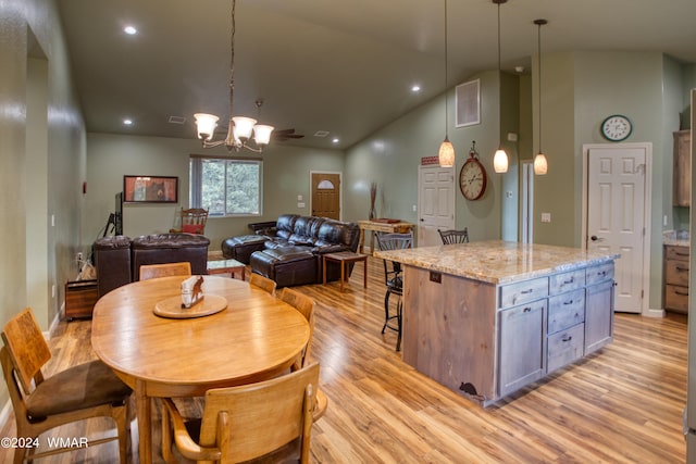 dining room featuring lofted ceiling, an inviting chandelier, light wood-type flooring, and visible vents