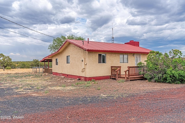 8460 Powells Ln, Show Low, AZ 85901 - view of property exterior featuring stucco siding, a wooden deck, and metal roof