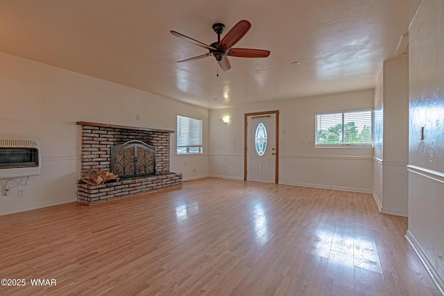 8460 Powells Ln, Show Low, AZ 85901 - unfurnished living room featuring a brick fireplace, heating unit, ceiling fan, light wood-style flooring, and baseboards