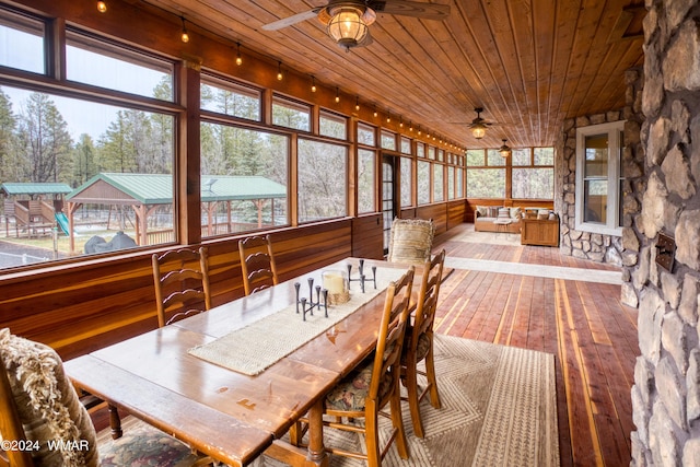 sunroom / solarium with wood ceiling and a ceiling fan