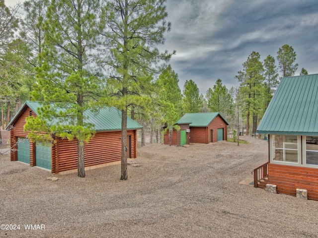 view of yard featuring a garage and an outbuilding