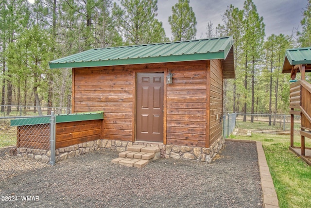 view of outdoor structure featuring fence and an outdoor structure