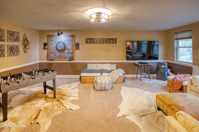 recreation room with carpet and baseboards