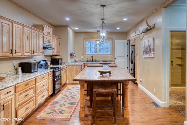 kitchen with black appliances, visible vents, under cabinet range hood, light brown cabinets, and wooden counters