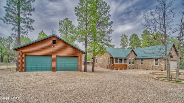 view of front of property featuring a detached garage and log siding