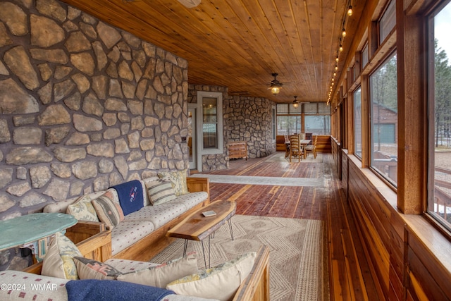 unfurnished sunroom featuring wood ceiling and ceiling fan