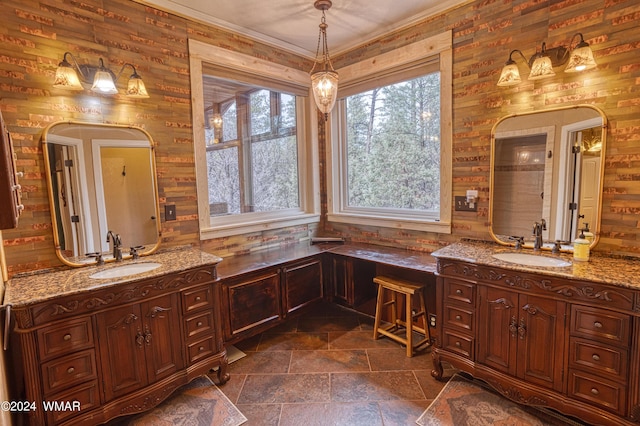 full bathroom featuring ornamental molding, two vanities, and a sink