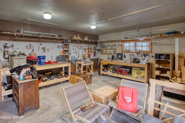 interior space with unfinished concrete flooring, a textured ceiling, and a workshop area