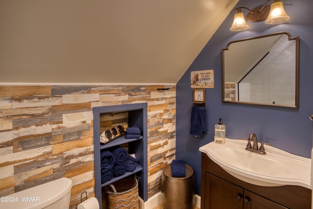 bathroom featuring lofted ceiling, vanity, and toilet