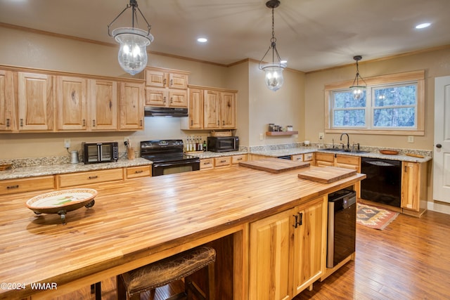 kitchen with hanging light fixtures, black appliances, butcher block counters, and ornamental molding