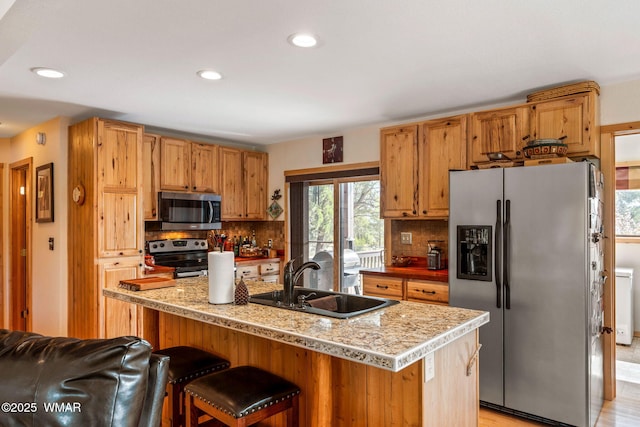 kitchen with recessed lighting, stainless steel appliances, decorative backsplash, and a sink