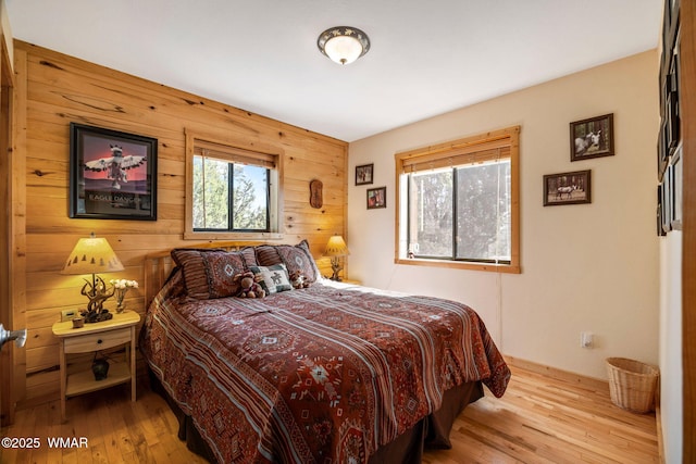 bedroom featuring wood walls and hardwood / wood-style flooring