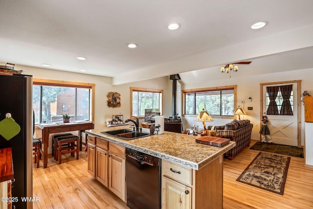 kitchen with a sink, freestanding refrigerator, light wood finished floors, and dishwasher