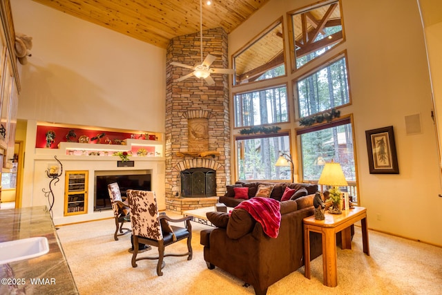 carpeted living room featuring a fireplace, high vaulted ceiling, ceiling fan, and wooden ceiling