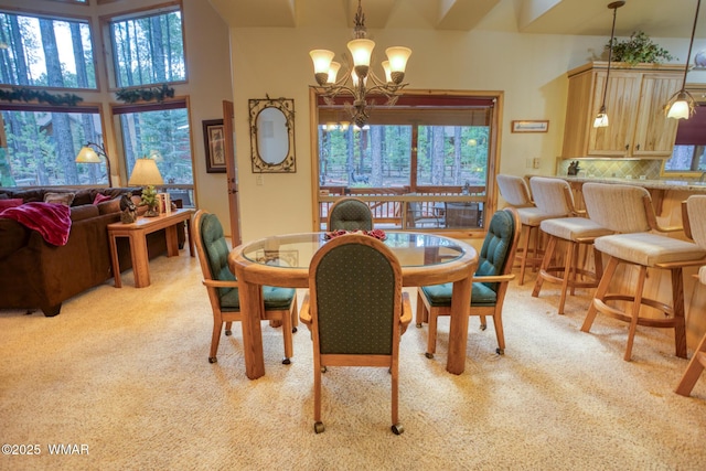 dining space with light carpet and an inviting chandelier