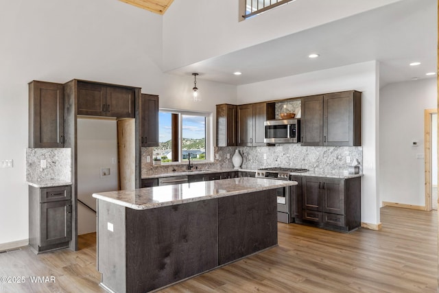 436 E 11th Ln, Eagar, AZ 85925 - kitchen featuring stainless steel appliances, decorative backsplash, light wood-style flooring, and dark brown cabinets