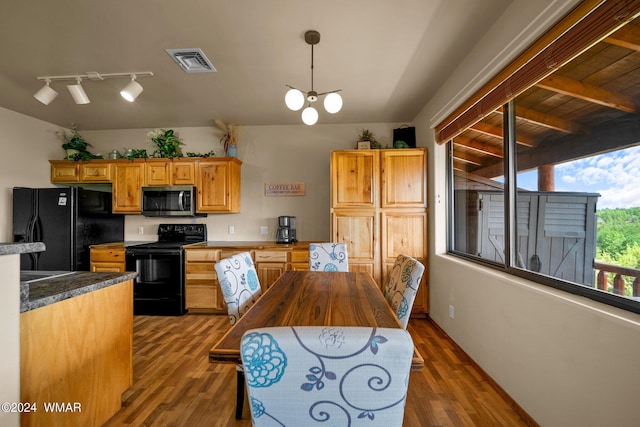 kitchen featuring visible vents, dark countertops, dark wood-style floors, black appliances, and pendant lighting