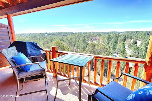 balcony featuring a wooded view