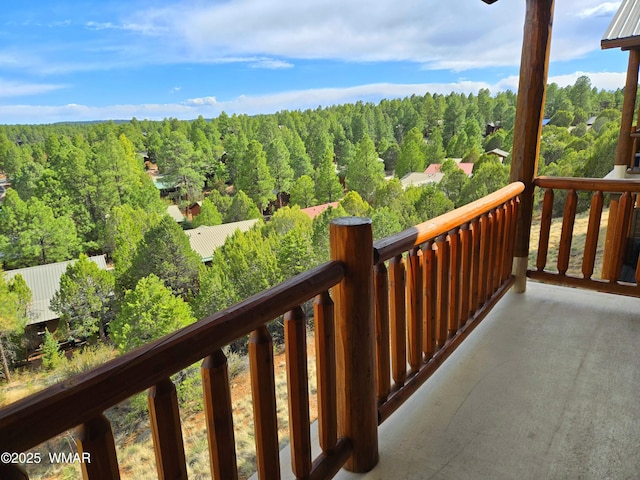 balcony featuring a wooded view