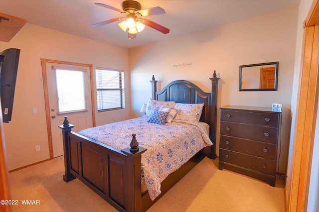 bedroom featuring light carpet, a ceiling fan, and baseboards