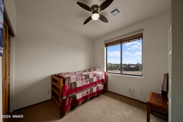 bedroom featuring light carpet, ceiling fan, visible vents, and baseboards