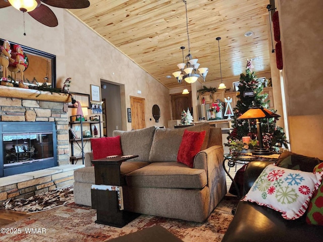 living area featuring ceiling fan with notable chandelier, high vaulted ceiling, a stone fireplace, and wood ceiling