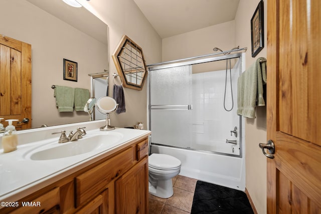 bathroom with toilet, bath / shower combo with glass door, vanity, and tile patterned floors