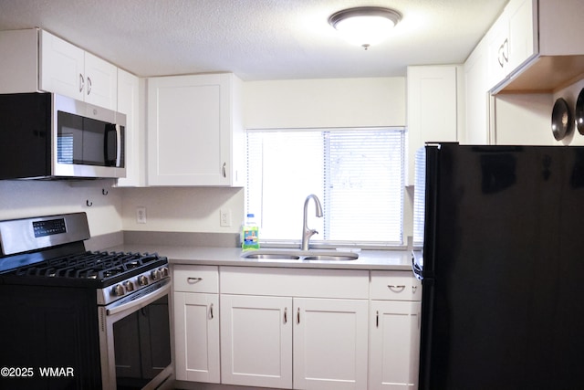 2853 Markham Rd, Overgaard, AZ 85933 - kitchen with appliances with stainless steel finishes, a sink, white cabinetry, and a textured ceiling