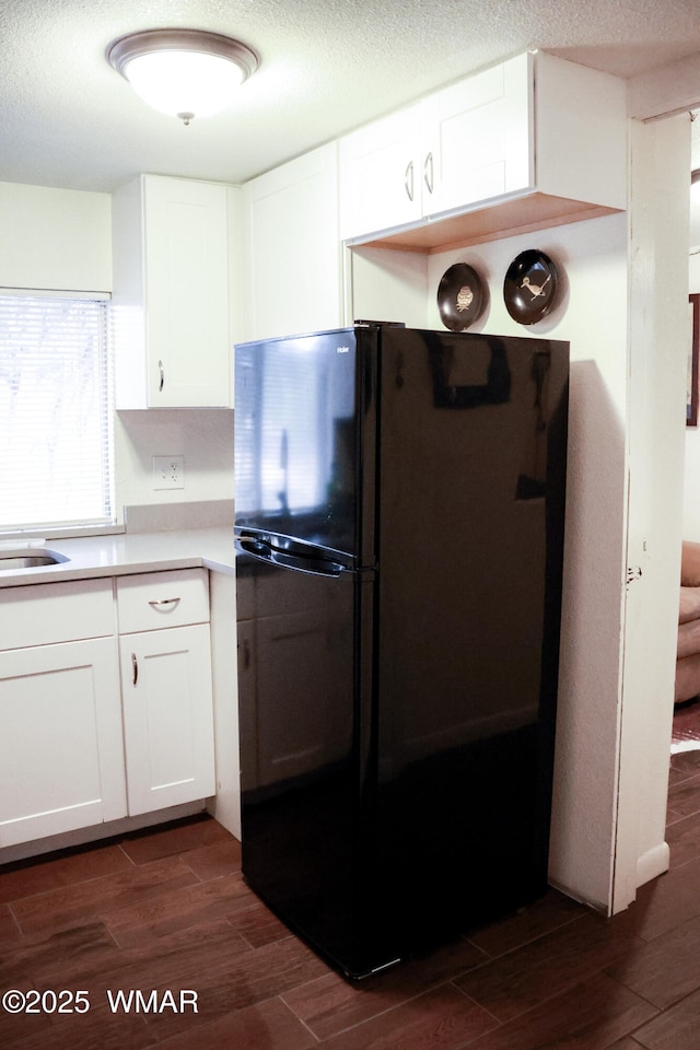 2853 Markham Rd, Overgaard, AZ 85933 - kitchen with freestanding refrigerator, dark wood-style floors, white cabinets, light countertops, and a textured ceiling