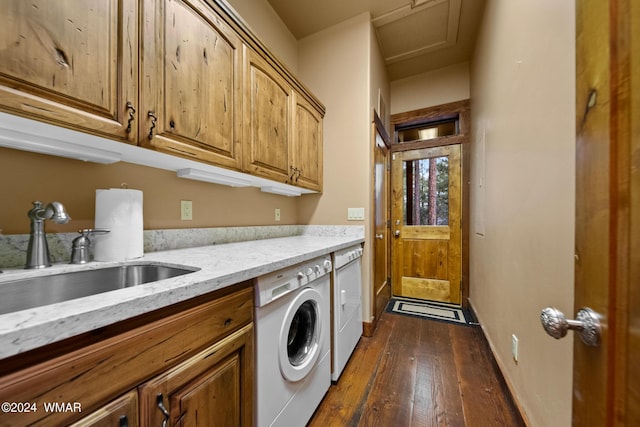 laundry area featuring washing machine and clothes dryer, a sink, baseboards, cabinet space, and dark wood finished floors