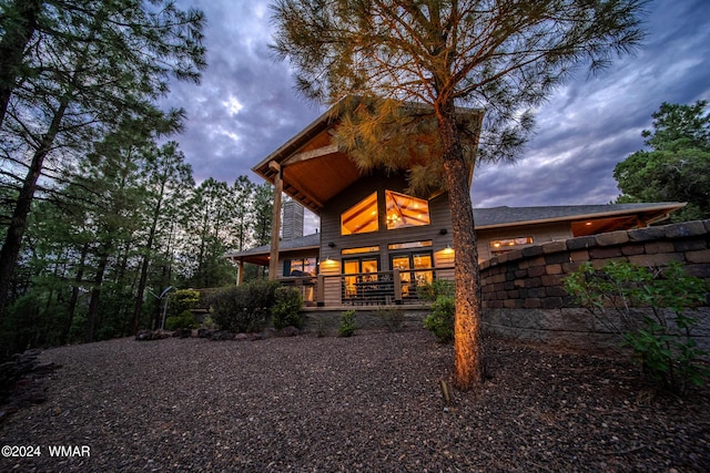 back of property at dusk with a porch