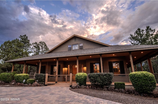 view of front of home with covered porch and roof with shingles