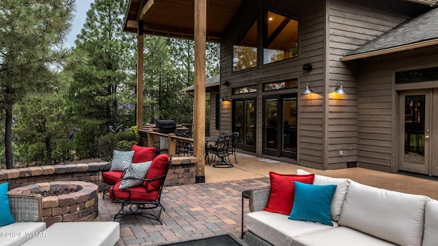 view of patio / terrace with an outdoor living space with a fire pit, outdoor dining area, and french doors