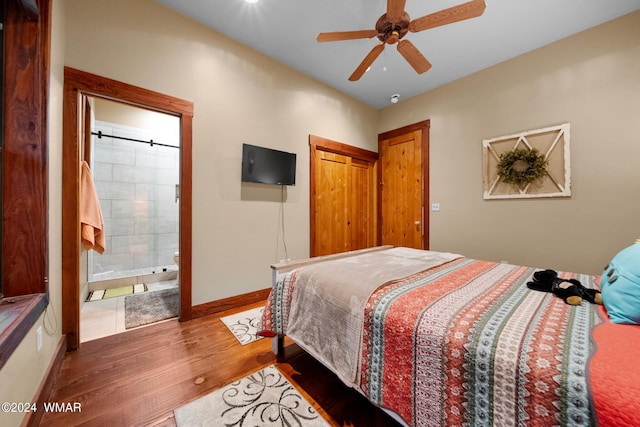 bedroom with ceiling fan, connected bathroom, wood finished floors, baseboards, and a closet