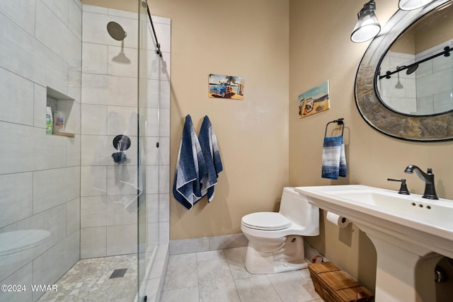 bathroom with baseboards, a tile shower, toilet, and tile patterned floors