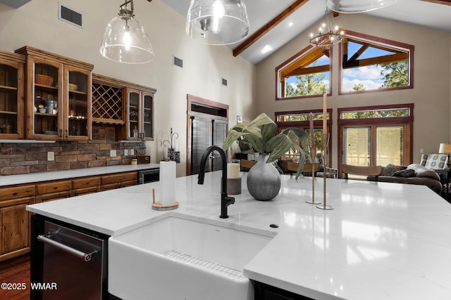 kitchen with open floor plan, light countertops, tasteful backsplash, and a sink