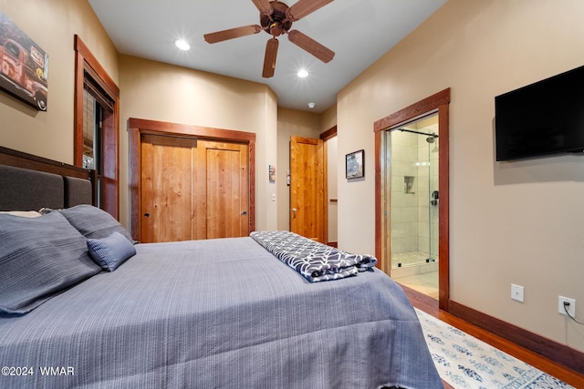 bedroom featuring baseboards, ensuite bath, wood finished floors, a closet, and recessed lighting