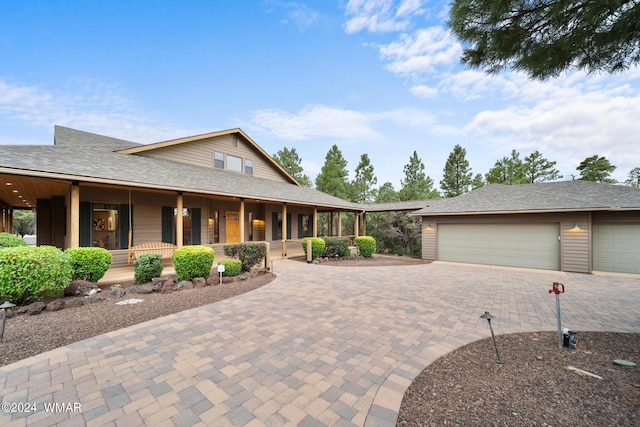 view of front of property featuring a shingled roof, covered porch, and decorative driveway