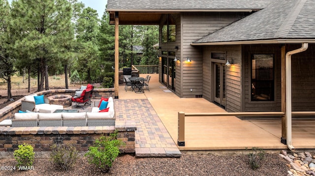 view of patio with an outdoor living space with a fire pit