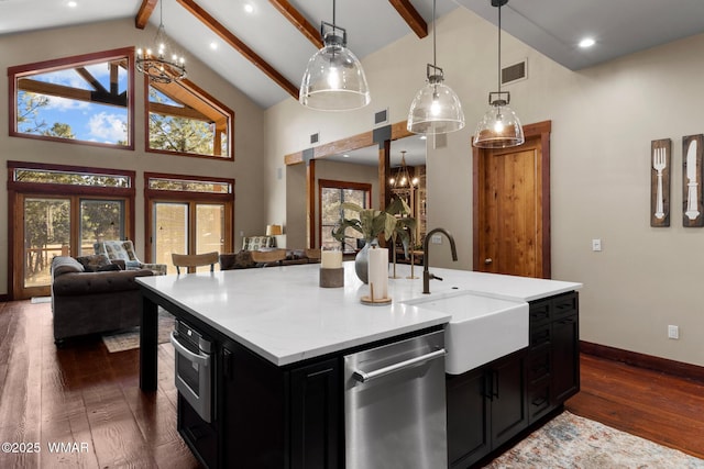 kitchen with visible vents, dark cabinets, a notable chandelier, stainless steel appliances, and a sink