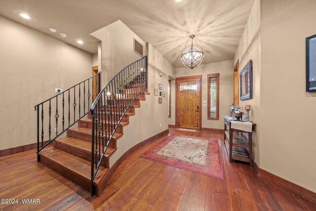 foyer entrance featuring stairway, wood-type flooring, visible vents, and baseboards