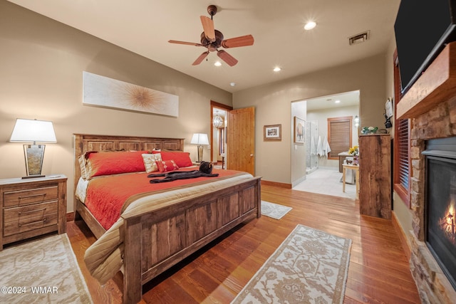 bedroom with baseboards, visible vents, light wood-style floors, a fireplace, and recessed lighting