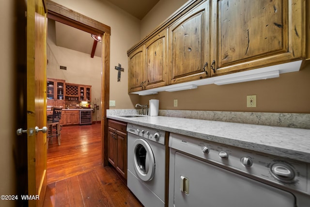 laundry area with wine cooler, cabinet space, a sink, and washer and clothes dryer